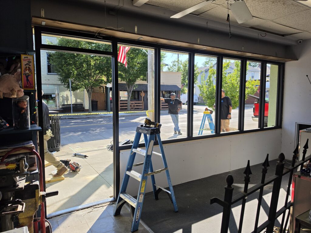 New black aluminum storefront frames seen from inside Rich's Pawn Shop during the rebuild.