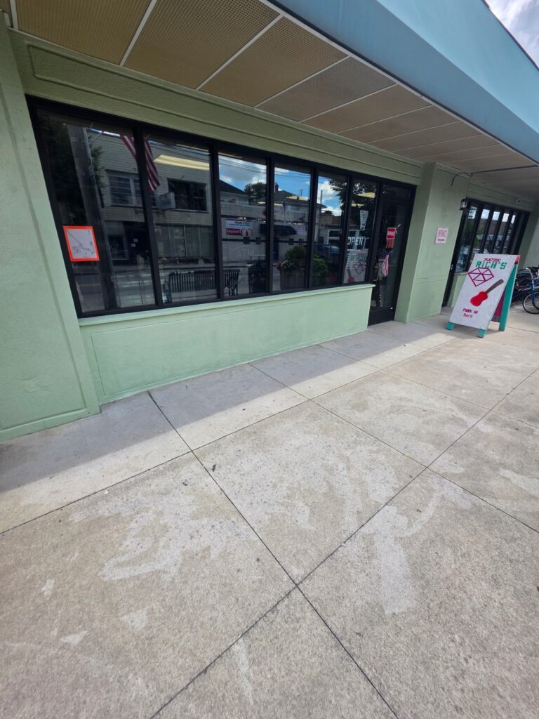 Completed storefront replacement in Dayton with black aluminum frames and a freshly stuccoed knee wall.